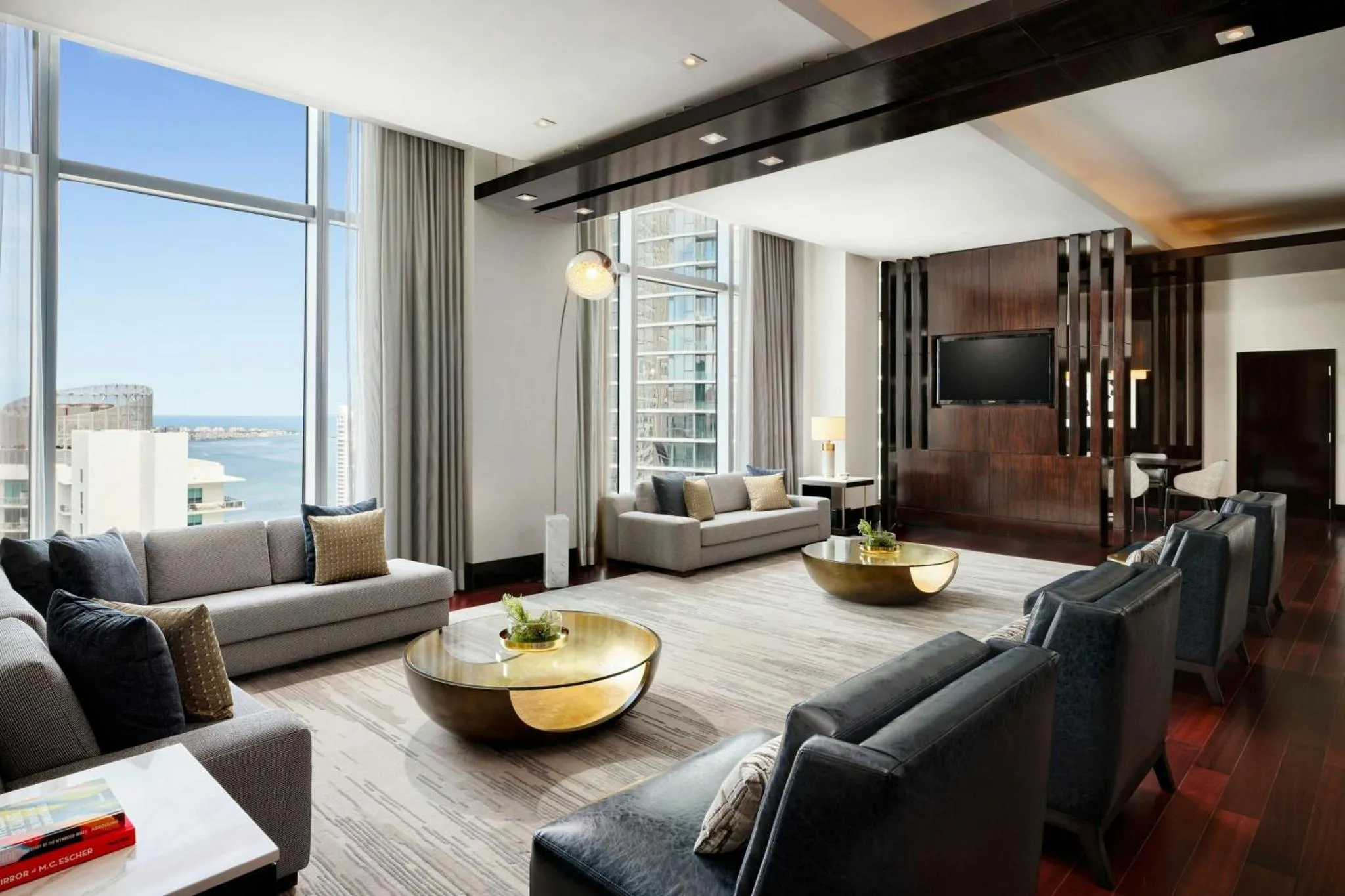 Un salon spacieux avec de grands canapés et une vue sur la mer par de larges fenêtres.