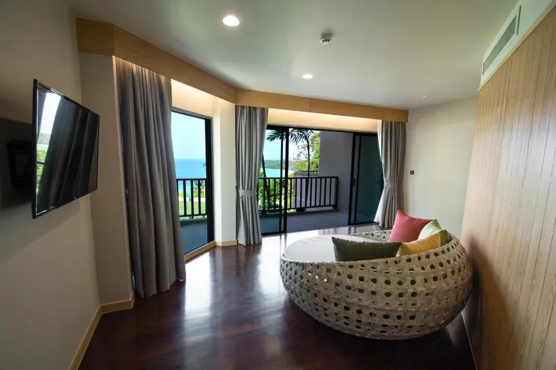 Un espace de détente intérieur avec un canapé rond et une vue sur l'extérieur.