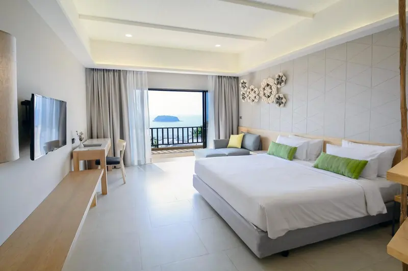 Une chambre lumineuse avec un grand lit et une vue sur la mer.