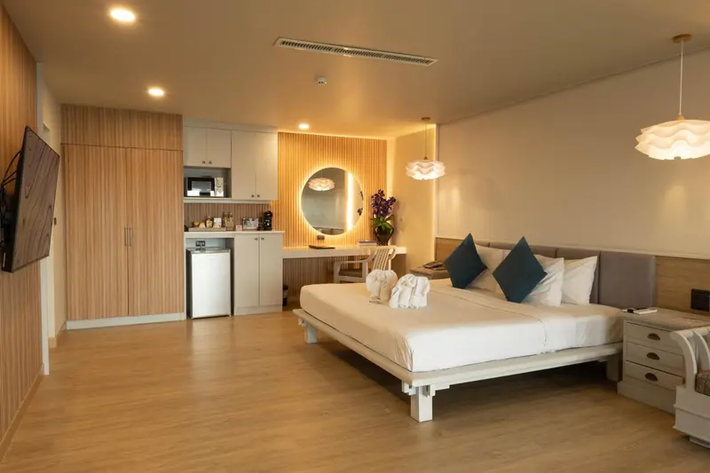 Chambre lumineuse avec un grand lit et un décor moderne.