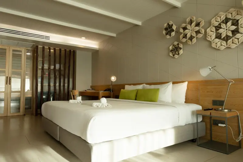 Une chambre lumineuse avec un grand lit et une décoration murale.