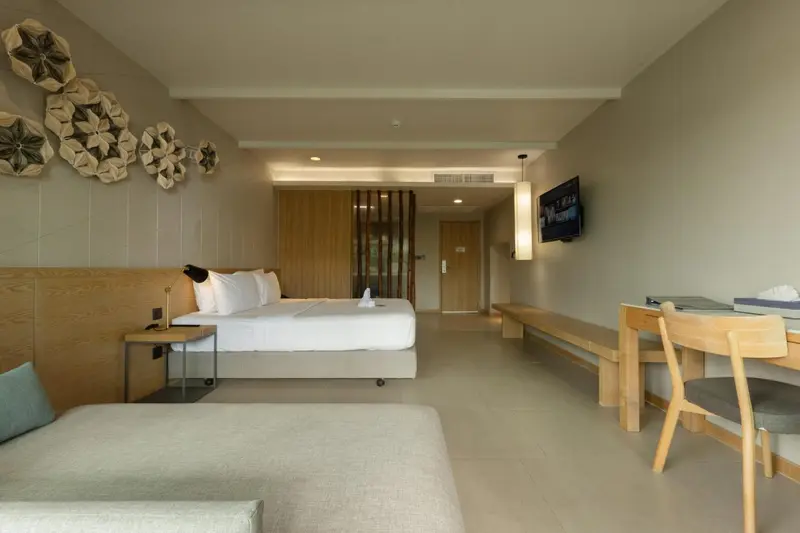 Une chambre lumineuse avec un grand lit et un espace détente.