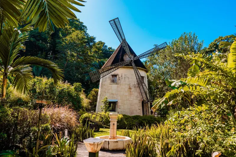 Un moulin à vent en pierre se dresse au milieu d'une végétation luxuriante.