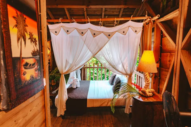 Un lit à baldaquin dans une chambre décorée de manière tropicale.