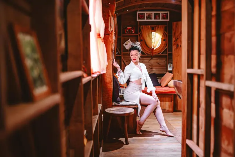 Une femme assise sur un tabouret dans un intérieur en bois chaleureux.