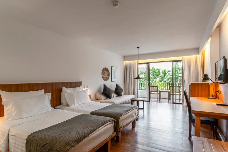 Une chambre lumineuse avec un grand lit et un espace détente.
