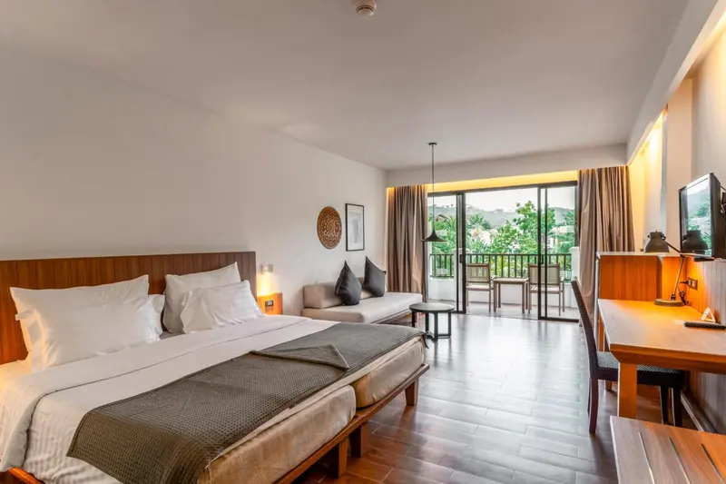 Une chambre lumineuse avec un grand lit et un espace détente.
