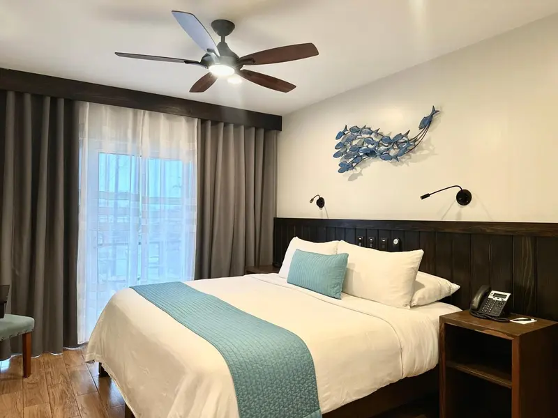Une chambre lumineuse avec un grand lit et une décoration marine.