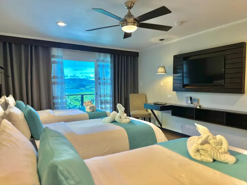 Chambre avec lits jumeaux et vue sur la végétation.