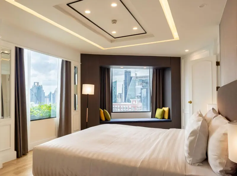 Une chambre lumineuse avec un grand lit et une fenêtre en baie.