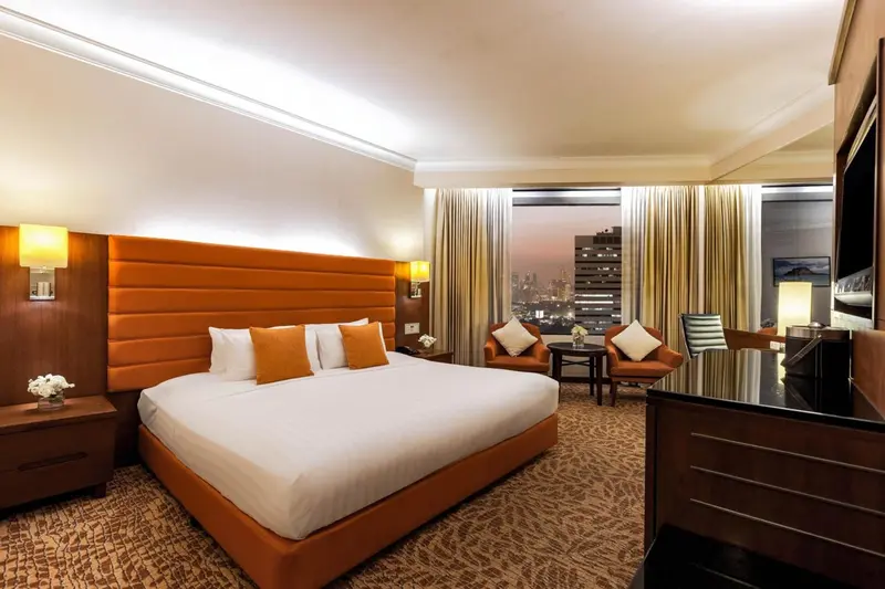 Chambre d'hôtel moderne avec un grand lit et un coin salon.