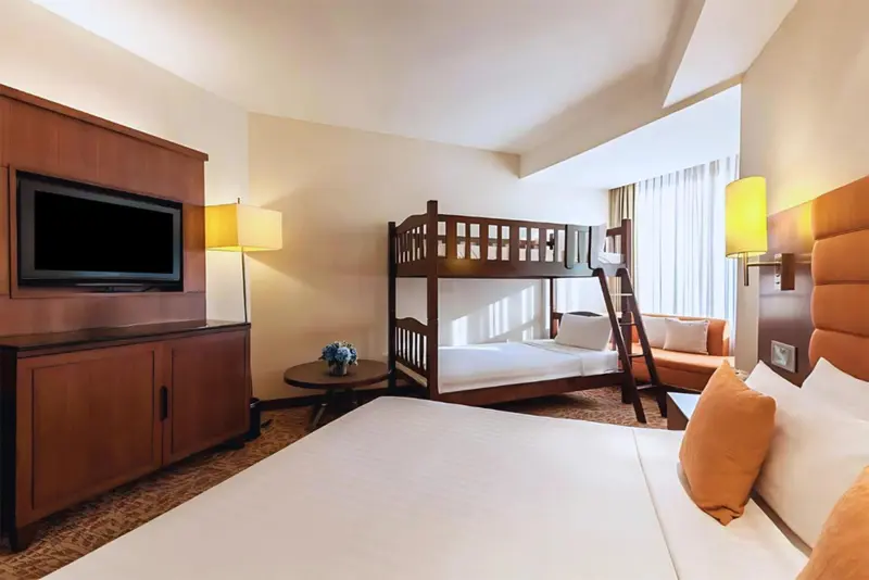 Une chambre avec un lit superposé et un lit simple.