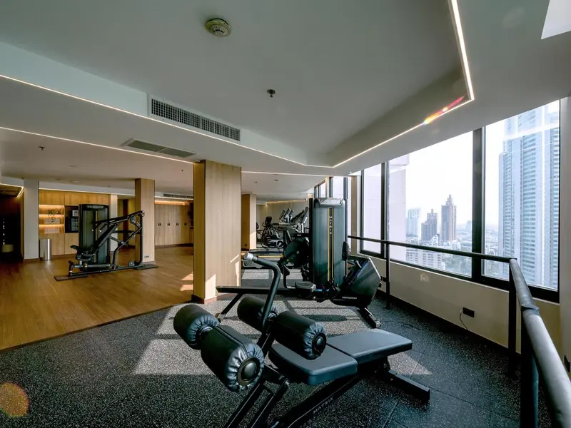 Une salle de sport lumineuse avec des équipements de musculation et une vue sur la ville.