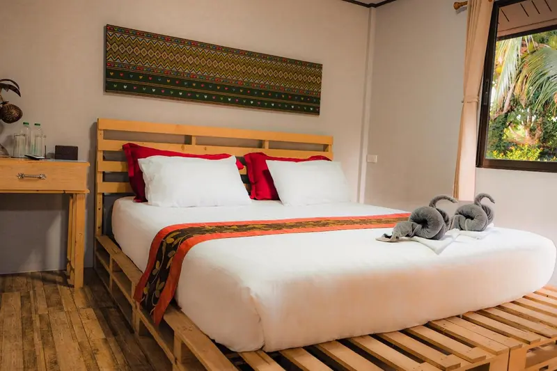 Une chambre lumineuse avec un grand lit recouvert d'une courtepointe colorée.