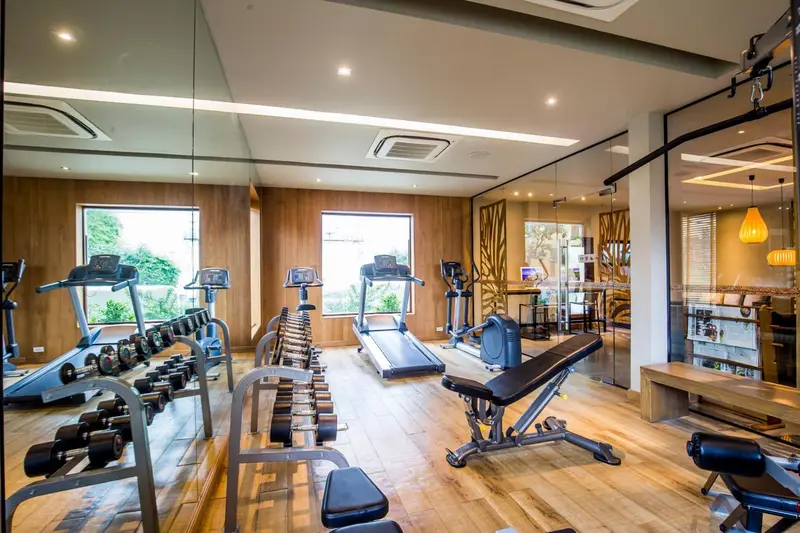Une salle de sport lumineuse avec des équipements de musculation et de cardio.