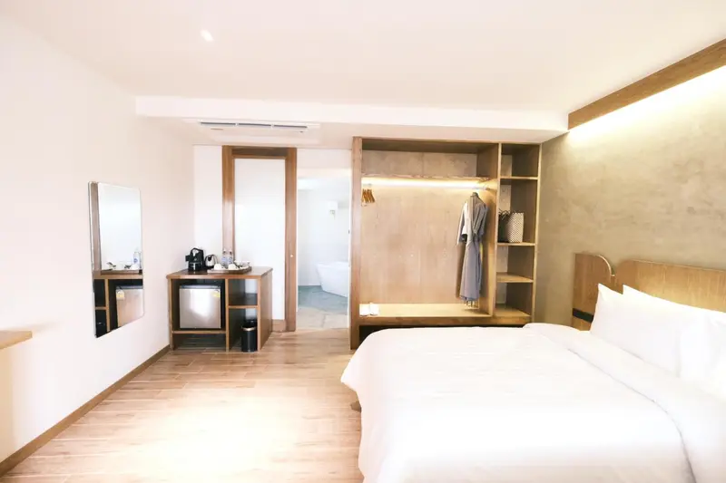 Une chambre lumineuse avec un grand lit et un espace rangement intégré.