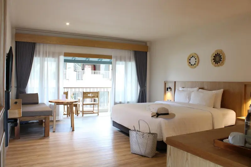 Chambre lumineuse avec un grand lit et un espace détente.