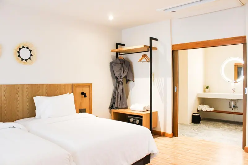 Une chambre lumineuse avec un grand lit et un accès à une salle de bain.
