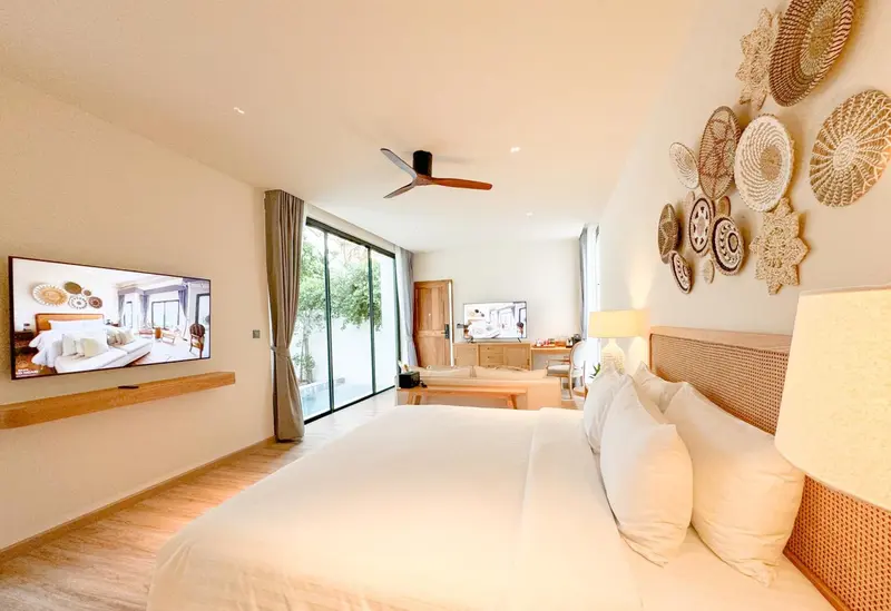 Une chambre lumineuse avec un grand lit et une décoration murale en vannerie.