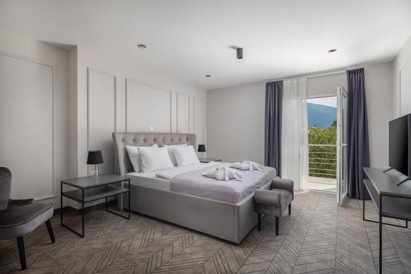 Une chambre lumineuse avec un grand lit et un accès à une terrasse.