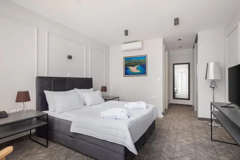 Une chambre moderne avec un grand lit et une décoration sobre.