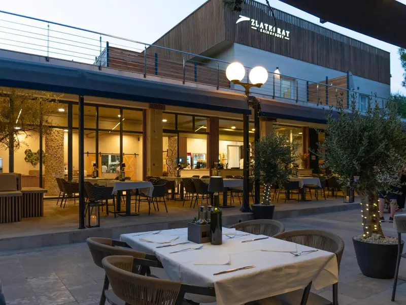 Terrasse de restaurant avec tables dressées et éclairage d'ambiance.