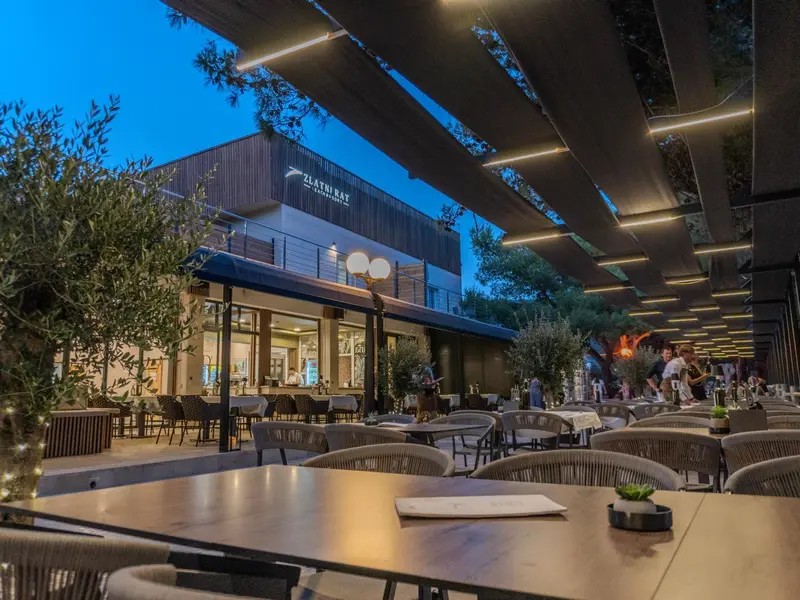 Terrasse de restaurant avec tables et chaises en soirée.