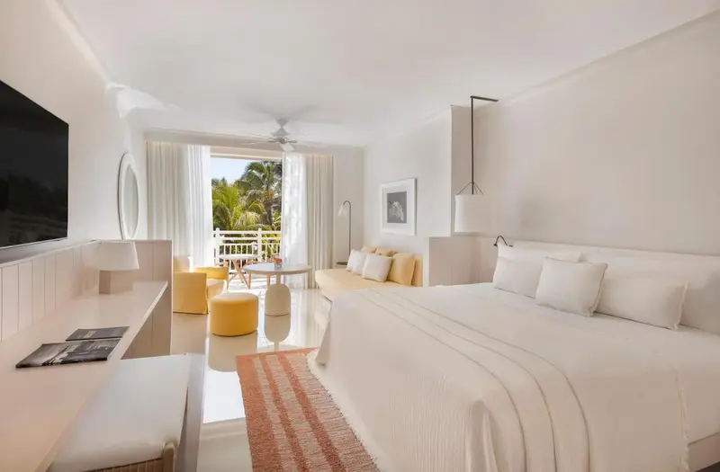 Une chambre lumineuse avec un grand lit et un espace détente.