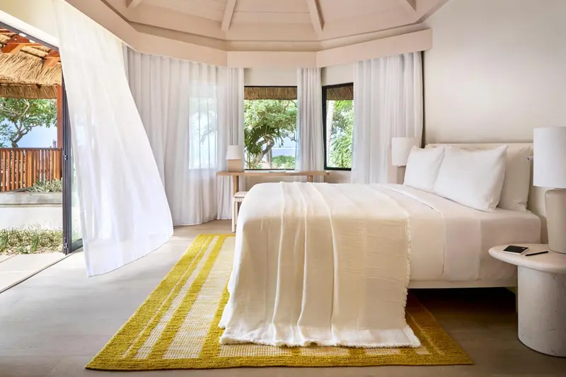 Une chambre lumineuse avec un grand lit et un accès à une terrasse.