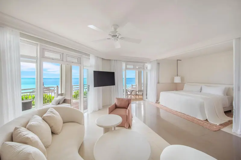 Espace de vie lumineux avec canapé et lit donnant sur la mer.