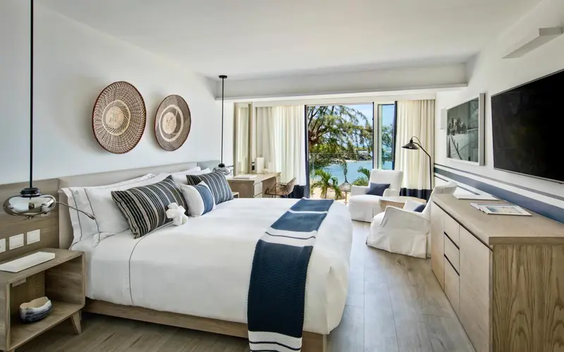 Une chambre lumineuse avec un grand lit et une vue sur la mer.
