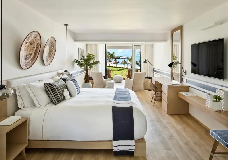 Une chambre lumineuse avec un grand lit et une vue sur la mer.