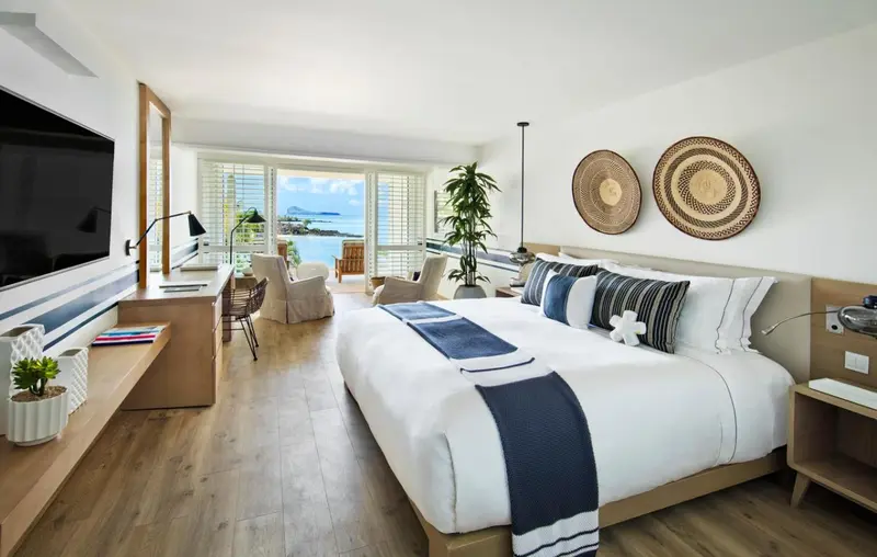 Une chambre lumineuse avec un grand lit et une vue sur la mer.