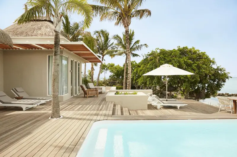 Terrasse en bois avec piscine et mobilier de détente.