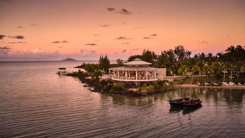Un restaurant en bord de mer au coucher du soleil.