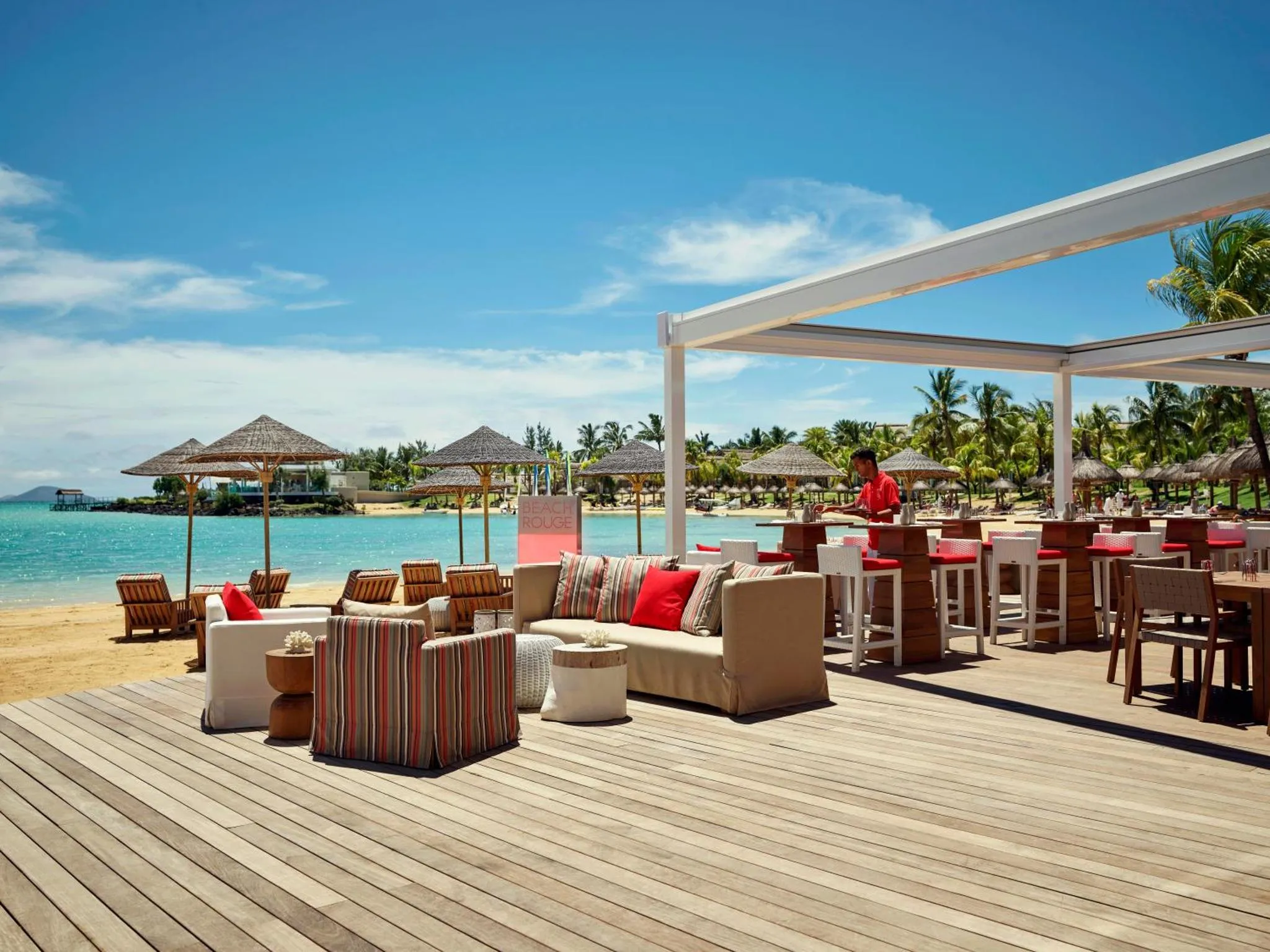 Espace de détente extérieur avec mobilier confortable face à la mer.