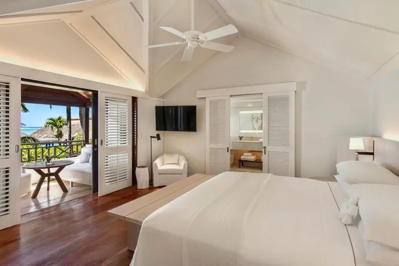 Chambre lumineuse avec un lit king-size et un accès à une terrasse.