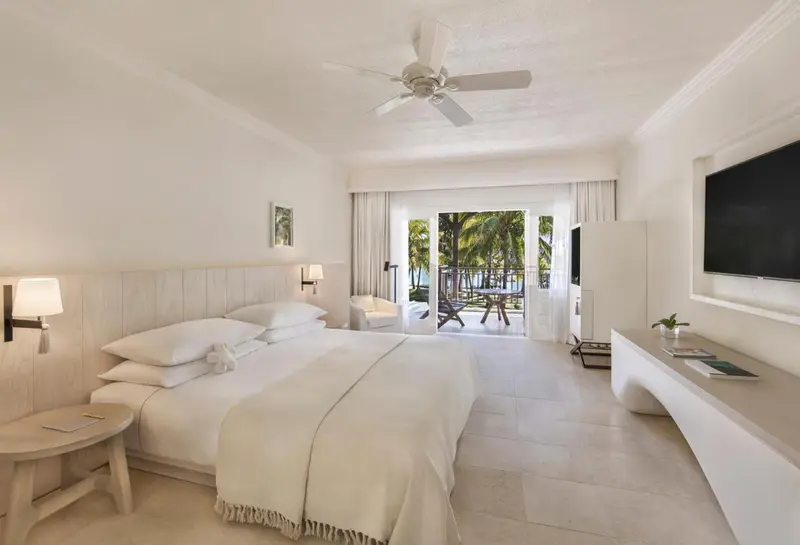 Une chambre lumineuse avec un grand lit et un accès à une terrasse.