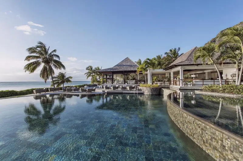 Une piscine à débordement offre une vue sur la mer et la végétation tropicale.