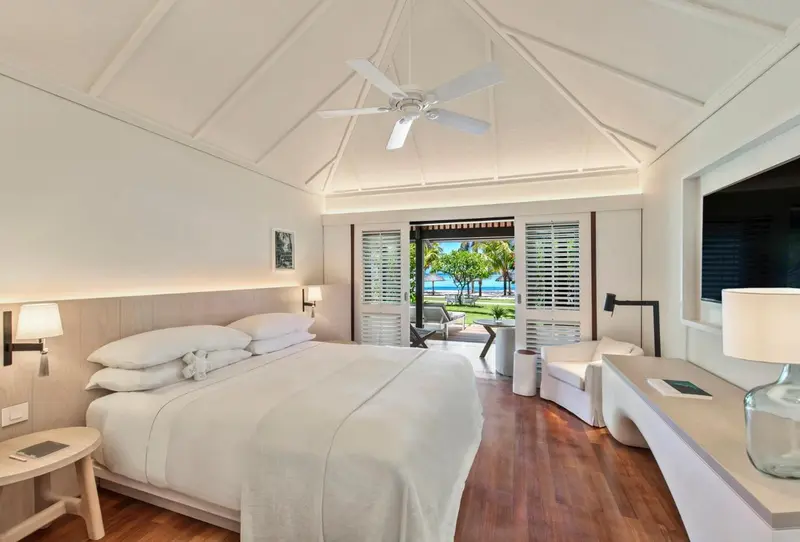 Une chambre lumineuse avec un grand lit et une vue sur la végétation.