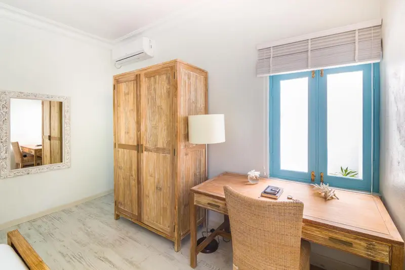 Une pièce lumineuse avec un bureau en bois et une fenêtre bleue.