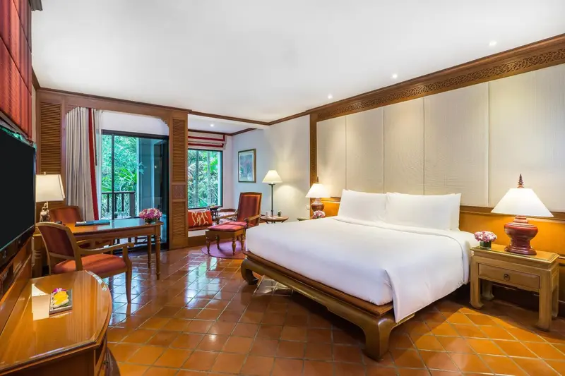 Une chambre lumineuse avec un grand lit et un bureau.