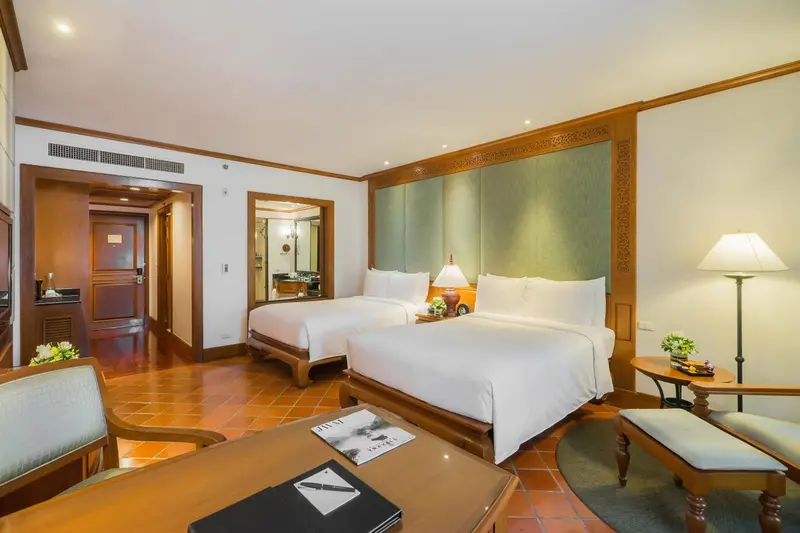 Chambre lumineuse avec deux lits simples et décoration florale.