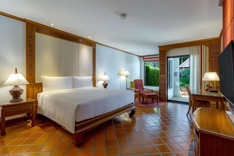 Une chambre lumineuse avec un grand lit et un coin salon.