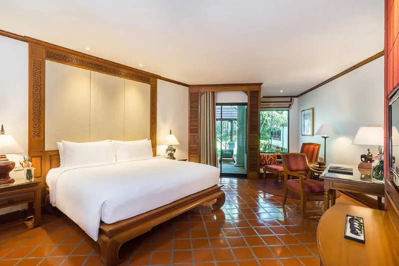 Une chambre lumineuse avec un grand lit et un coin salon.