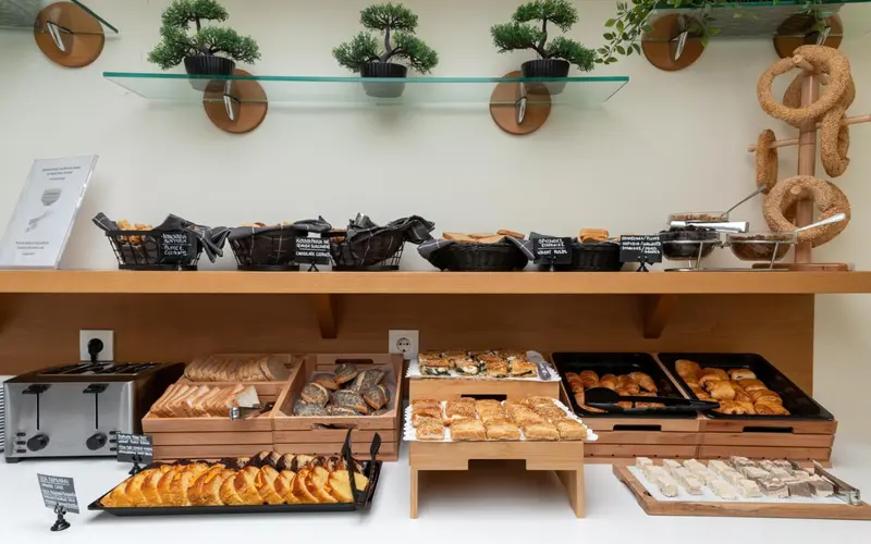 Présentation de viennoiseries et de pains sur un buffet.