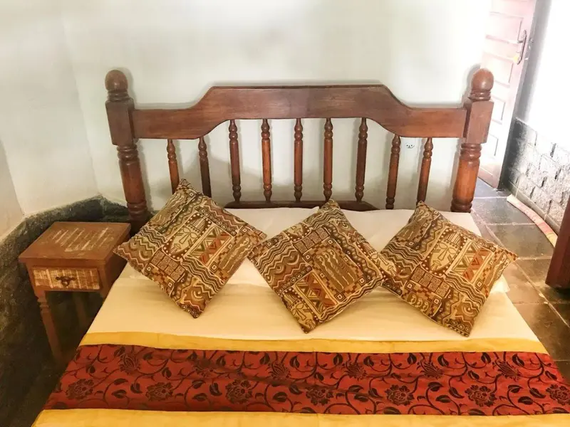 Un lit avec une tête de lit en bois et des coussins décoratifs.