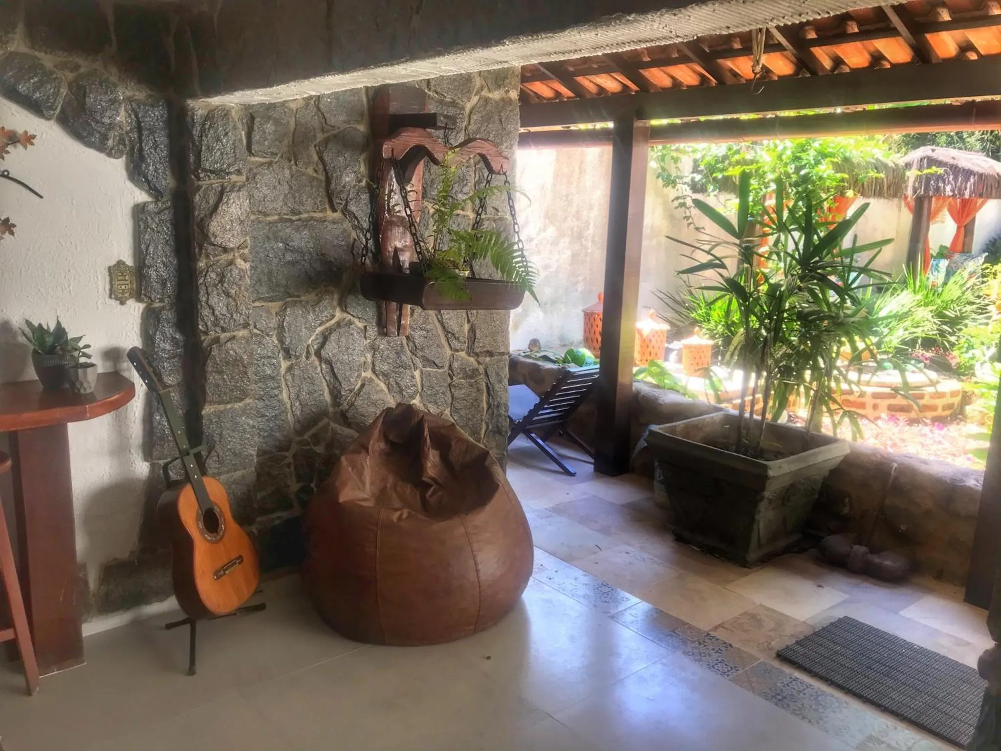 Espace de détente intérieur avec mobilier en bois et plantes vertes.