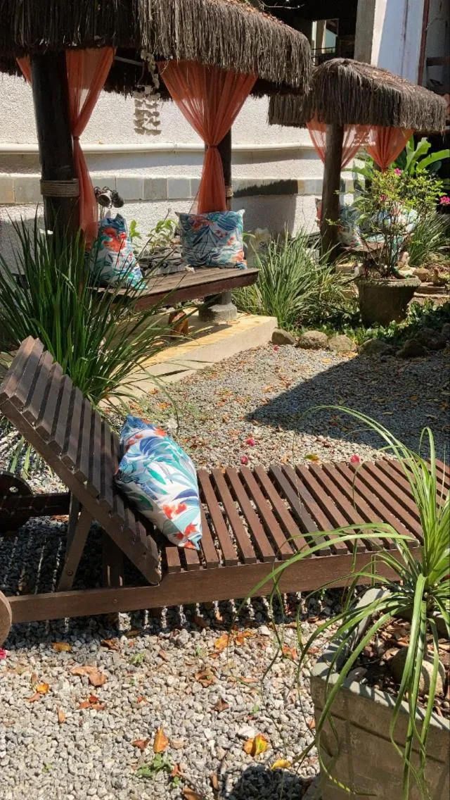 Espaces de détente extérieurs avec mobilier en bois et végétation tropicale.