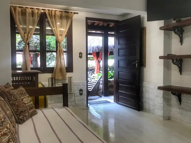 Une chambre lumineuse s'ouvre sur une terrasse ombragée.